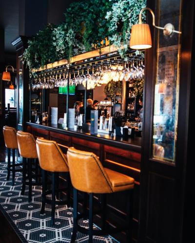 a bar with a row of chairs in a restaurant at The Parkview Hotel in Newtown Mount Kennedy