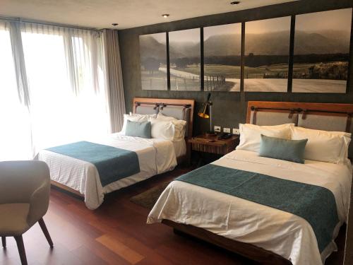 a hotel room with two beds and a large window at Gamma Monterrey Rincon de Santiago in Santiago