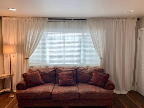a living room with a brown couch in front of a window at Stunning 3,400 sq ft Lake House w Boat Dock, Sauna, Steam Shower, and More in Clearlake Oaks