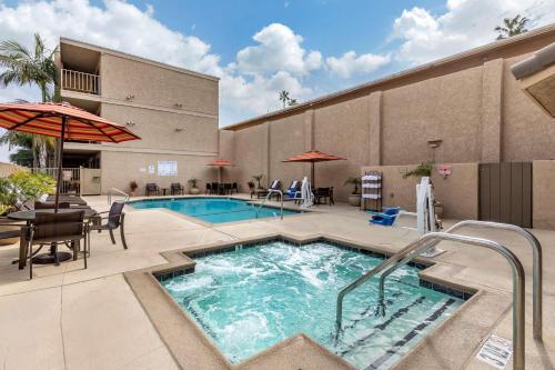 a pool at a hotel with a table and chairs at Best Western Plus Anaheim Inn in Anaheim