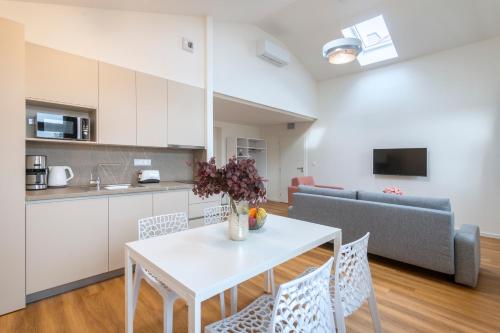 a kitchen and living room with a white table and chairs at Hidden Art Boutique Residence by Dwellfort in Prague