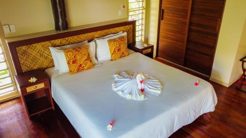 a bedroom with a bed with a flower on it at Saletoga Sands Resort & Spa in Matatufu
