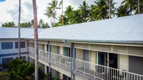 a building with a balcony and palm trees at Saletoga Sands Resort & Spa in Matatufu