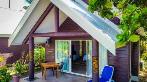 a house with a pitched roof with a table and chairs at Saletoga Sands Resort & Spa in Matatufu
