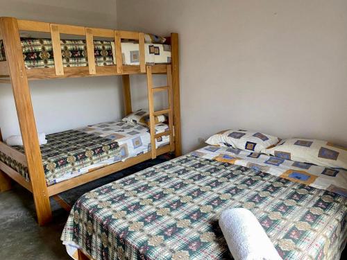a bedroom with two bunk beds and a bed at Las Cabañas de Incahuasi in Lunahuaná