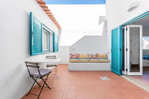 a room with a table and chairs on a tile floor at Casa Prainha, Alvor para 10 pessoas in Alvor