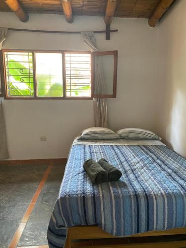 a bedroom with a bed with two pairs of shoes on it at Las Cabañas de Incahuasi in Lunahuaná