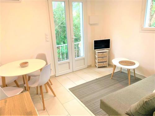 un salon avec une table et une télévision dans l'établissement VILLA BELLA, à La Seyne-sur-Mer