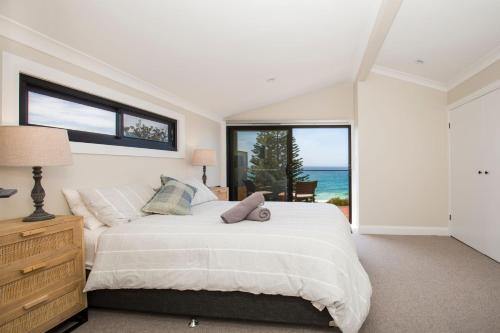 a bedroom with a large bed and a large window at Seaview I Pet Friendly with Stunning Views I 1 Min to Beach in Culburra Beach