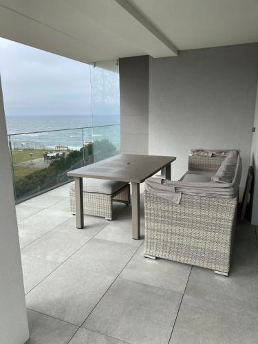 a table and chairs in a room with a view of the ocean at Relax Planet in Rewal
