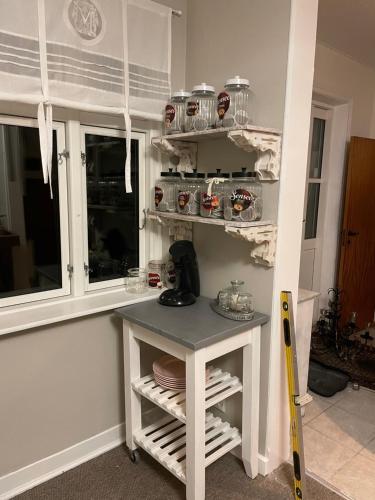 a kitchen with a table and shelves with dishes at Den Gamle Apotekergaard in Høng