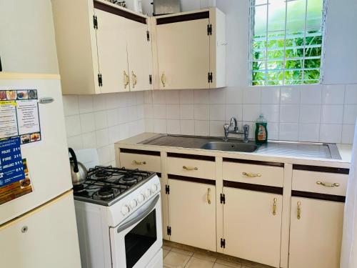 cocina con armarios blancos y fogones en Ocean View Apartments en Bridgetown