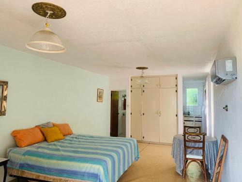 1 dormitorio con 1 cama, mesa y sillas en Ocean View Apartments en Bridgetown