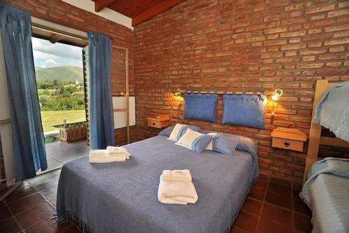 a bedroom with a large bed with towels on it at Castelar - Hotel & Apart in Huerta Grande