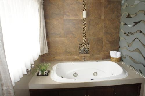 a bath tub in a bathroom with a window at Hotel Suites Teziutlan in Teziutlán