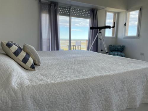 1 dormitorio con 1 cama y vistas al océano en Las Piedritas Monoambiente Vista en Las Grutas