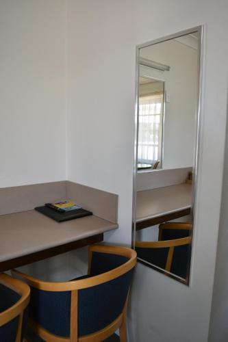 a mirror in a room with a table and chairs at Ten Dollar Town Motel in Gulgong