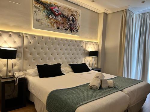 una camera d'albergo con due letti e un telefono di Hotel Suites Feria de Madrid a Madrid