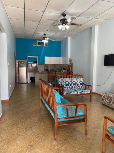 a living room with wooden chairs and a couch at Casa con piscina en salinas cerca del mar in Salinas