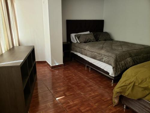 een slaapkamer met een bed en een houten vloer bij Entire family apartment Cuscox4 in Cuzco