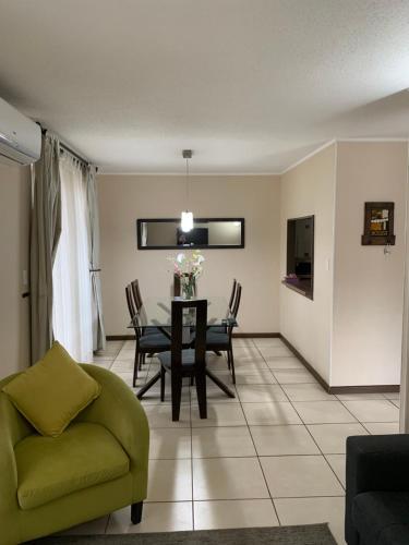 sala de estar con mesa y sofá verde en Casa arriendo Pucon, en Pucón