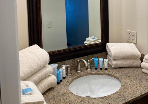 a bathroom with a sink and a mirror and towels at Georgian Lakeside Resort in Lake George