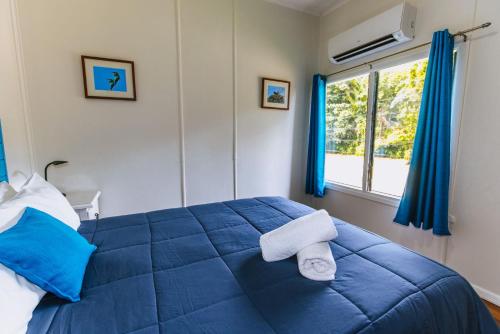 a bedroom with a blue bed with towels on it at Kooyong Apartment 2 in Arcadia