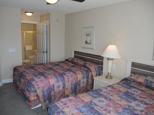 ein Hotelzimmer mit 2 Betten und einer Lampe in der Unterkunft Brunswick Plantation Golf Resort 1509M in Calabash