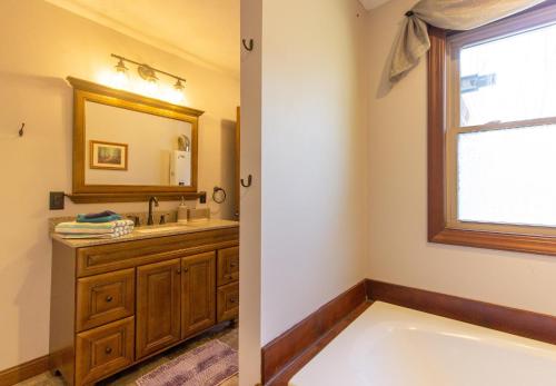 a bathroom with a tub and a sink and a window at The Chateau in Bloomington