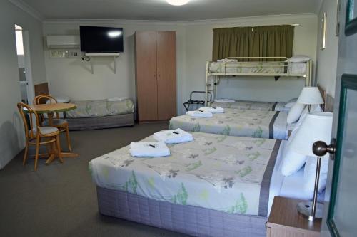 a hotel room with two beds and a tv at Ten Dollar Town Motel in Gulgong