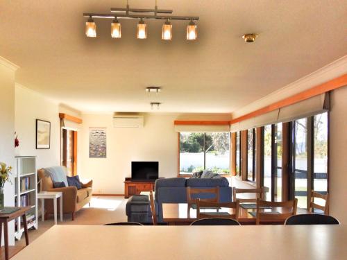 a living room with a couch and a table at Sea Eagle at Roaring Beach in Surveyors Bay