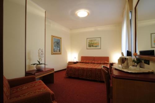 ein Hotelzimmer mit einem Bett und einem Schreibtisch in der Unterkunft Hotel Cristallo in Conegliano