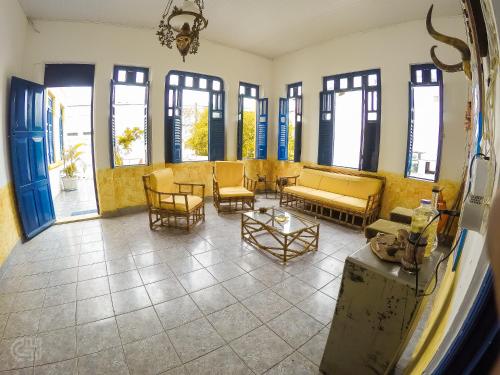 a living room with yellow furniture and windows at Hostel Andarai in Andaraí