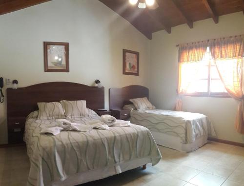 a bedroom with two beds and a window at DEL INFINITO in Capilla del Monte