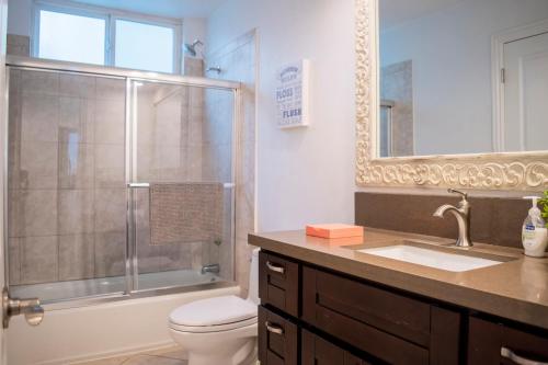 a bathroom with a shower and a toilet and a sink at Luxury Beachfront Condo - Endless Views - Surf 1 in Sunset Beach