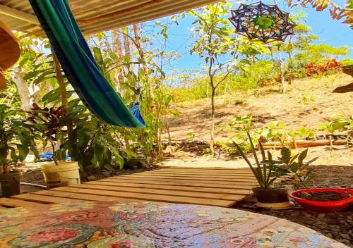 a wooden deck with a hammock and plants on it at Hostal Familiar El Ángel Panamá B&B in Pajonal Arriba