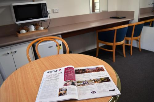 a table with a newspaper sitting on top of it at Ten Dollar Town Motel in Gulgong