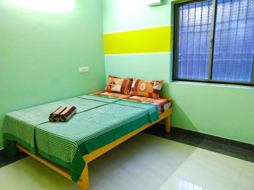 a small bedroom with a bed in a room at Villa Blossom, Near Serenity Beach in Pondicherry