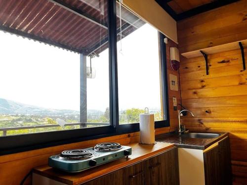 eine Küche mit einem Herd, einem Waschbecken und einem Fenster in der Unterkunft Villa Skape - Finca Villa Carolina in Villa de Leyva