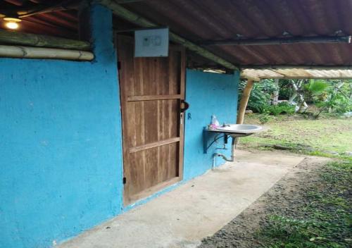 a blue house with a door and a sink at Hostal Familiar El Ángel Panamá B&B in Pajonal Arriba
