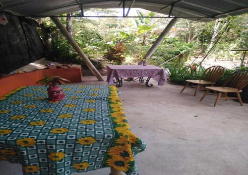 a quilt on a table under an umbrella on a patio at Hostal Familiar El Ángel Panamá B&B in Pajonal Arriba