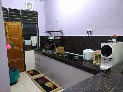 a kitchen with a counter top with a coffee maker at Yatida Homestay - Guest House Port Dickson in Port Dickson