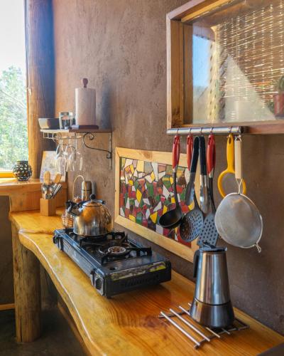 a kitchen counter with a stove and some utensils at Origen del Maipo Lodge in San José de Maipo