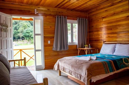 a bedroom with a bed in a wooden room at Pousada da Gruta in Urubici