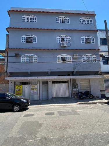 um edifício azul com um carro estacionado em frente em Cantinho do SOSSEGO, a 2 km da praia de Itapuã, no centro da cidade, wifi, ideal para CASAL em Vila Velha