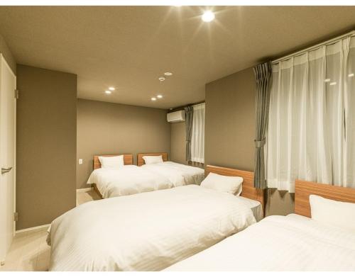 a bedroom with three beds and a window at Rakuten STAY HOUSE x WILL STYLE Matsue 103 in Matsue