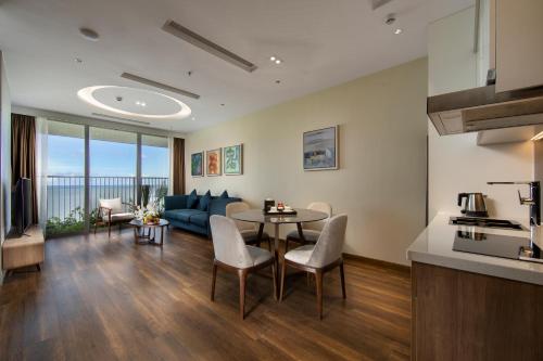 a kitchen and living room with a table and a couch at Flamingo Resort Cat Ba in Cat Ba