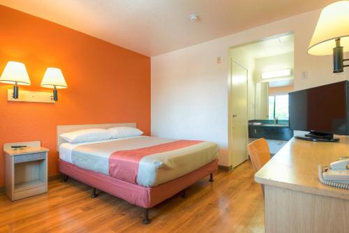 a bedroom with a bed with an orange wall at Motel 6-El Cajon, CA - San Diego in El Cajon