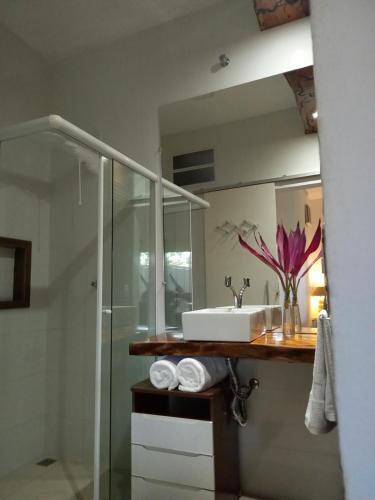 y baño con lavabo y espejo. en Suítes Mathias flat en Conservatória