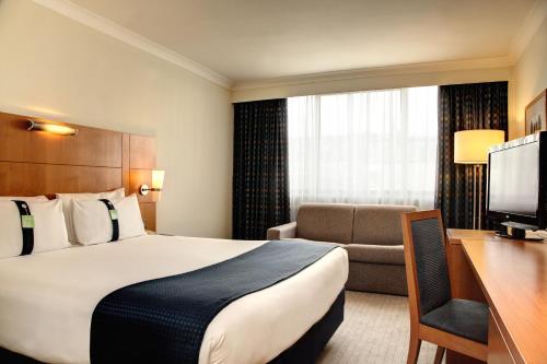 a hotel room with a bed and a desk at Holiday Inn London Bloomsbury, an IHG Hotel in London